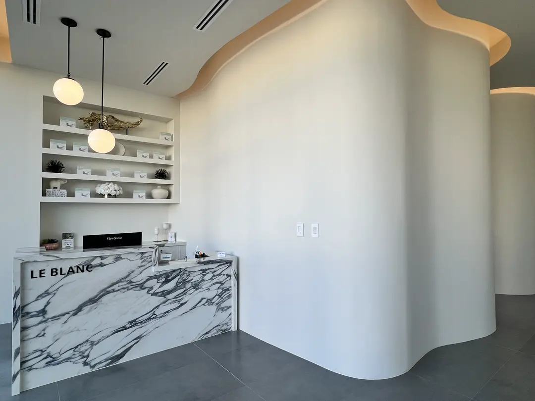 The LeBlanc reception desk, in marble, beside the curved wall
